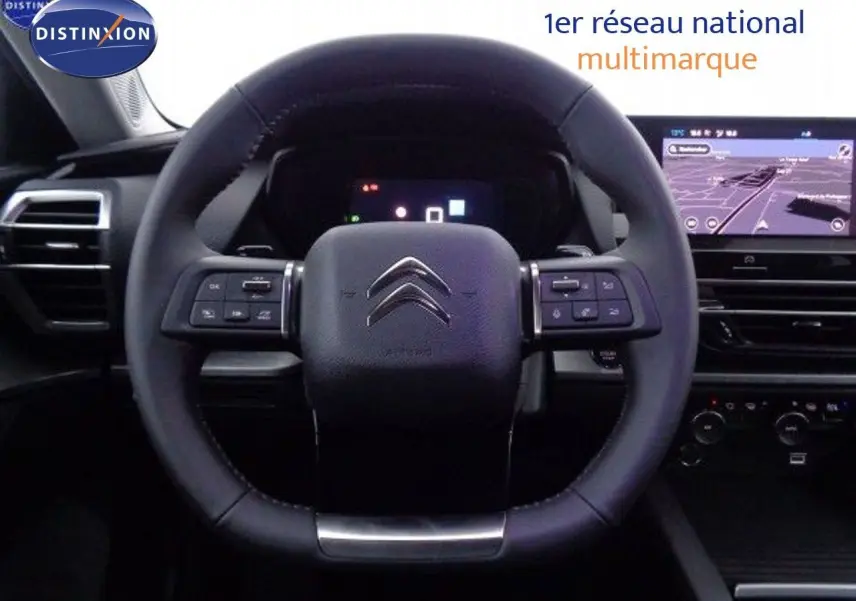 Vue rapprochée du volant cuir de la Citroën C5 X 2022 avec tableau de bord numérique et écran tactile de navigation.