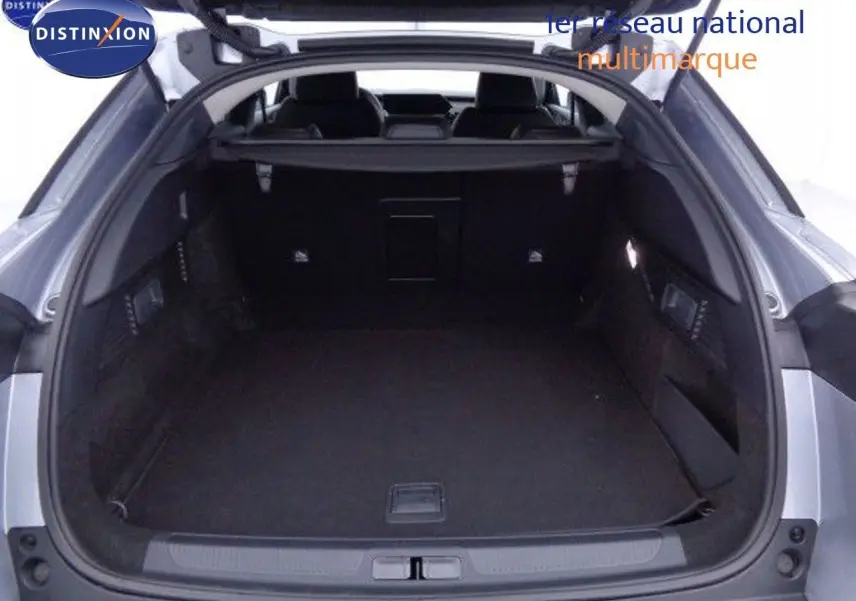 Coffre ouvert vu de l'arrière d'une Citroën C5 X gris Artense métal, montrant un espace de chargement spacieux et noir.