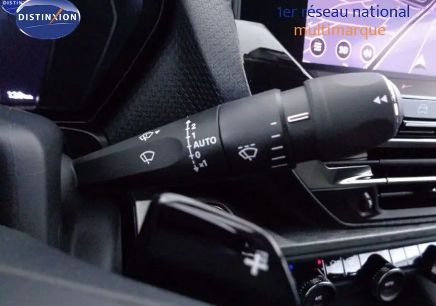 Gros plan sur la commande des essuie-glaces dans l'habitacle du Citroën C5 X gris Artense 2022 avec écran tactile en arrière-plan.