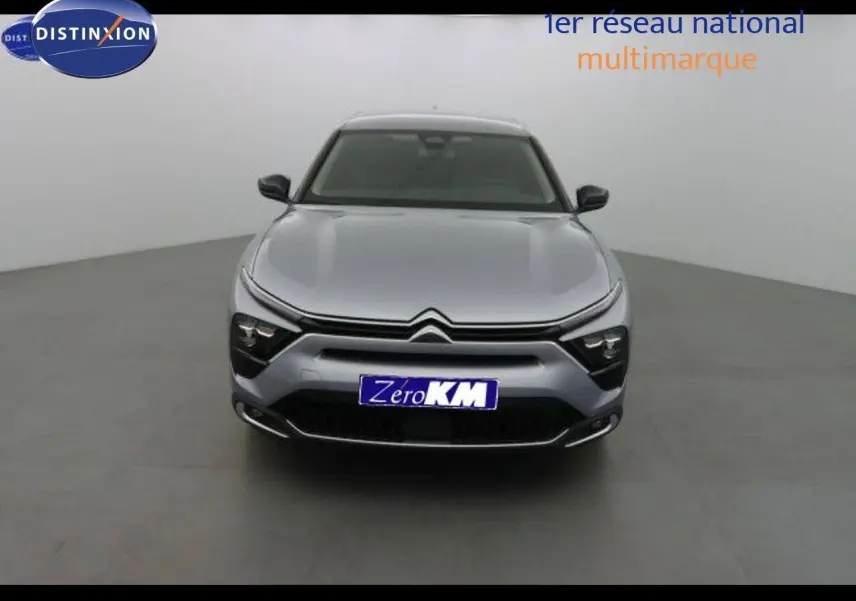 Vue frontale d'une Citroën C5 X gris Artense métal avec calandre distinctive et phares LED intégrés.