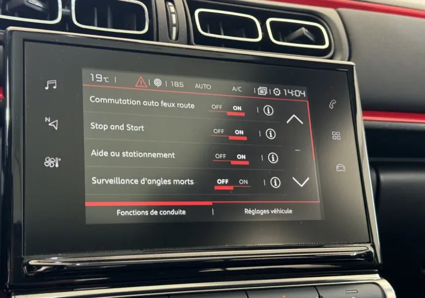 Écran tactile central affichant les réglages d'aide à la conduite dans l'habitacle noir et rouge d'une Citroën C3 2019.