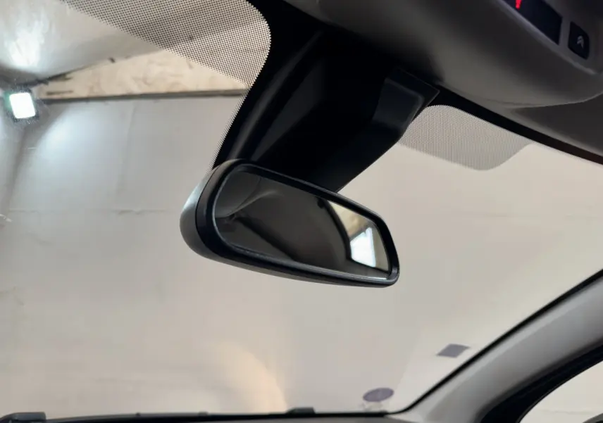 Vue intérieure rapprochée du rétroviseur central d’une Citroën C3 noire, 2019, avec pare-brise et ciel de toit visibles.
