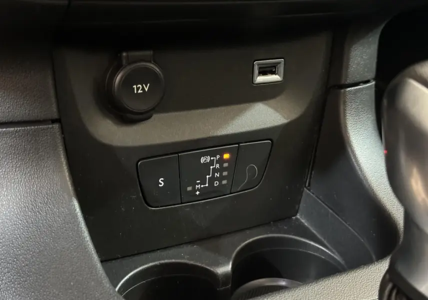 Gros plan sur la console centrale de la Citroën C3 noire, montrant la commande de boîte automatique et prise 12V.