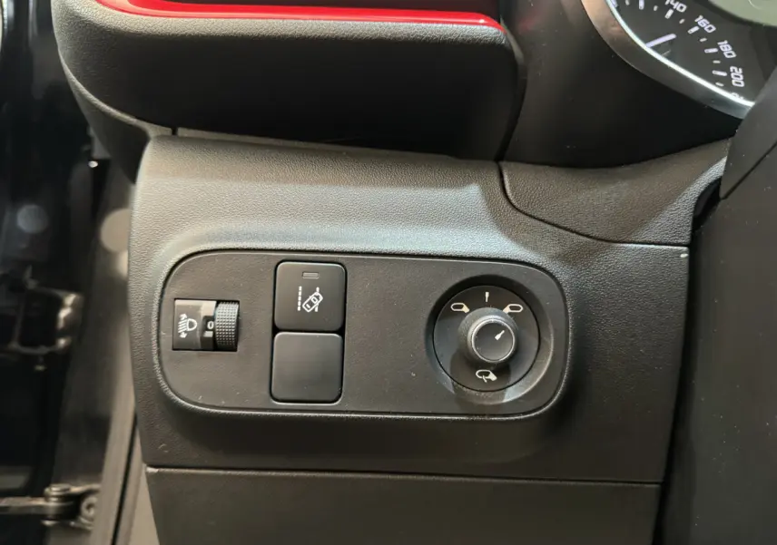 Gros plan sur les commandes de réglage des rétroviseurs et des phares côté gauche d'une Citroën C3 noire de 2019.