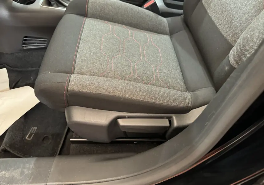 Gros plan sur le siège avant droit gris avec surpiqûres rouges de la Citroën C3 PureTech 110 noire de 2019.