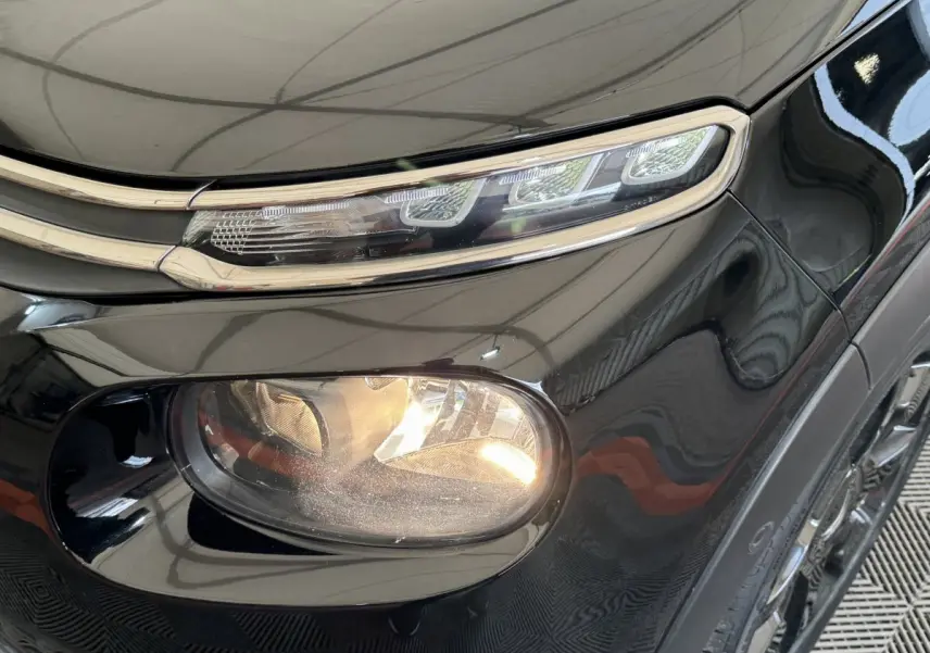 Gros plan sur le phare avant droit noir brillant d'une Citroën C3 2019 avec feux LED et antibrouillard intégré.