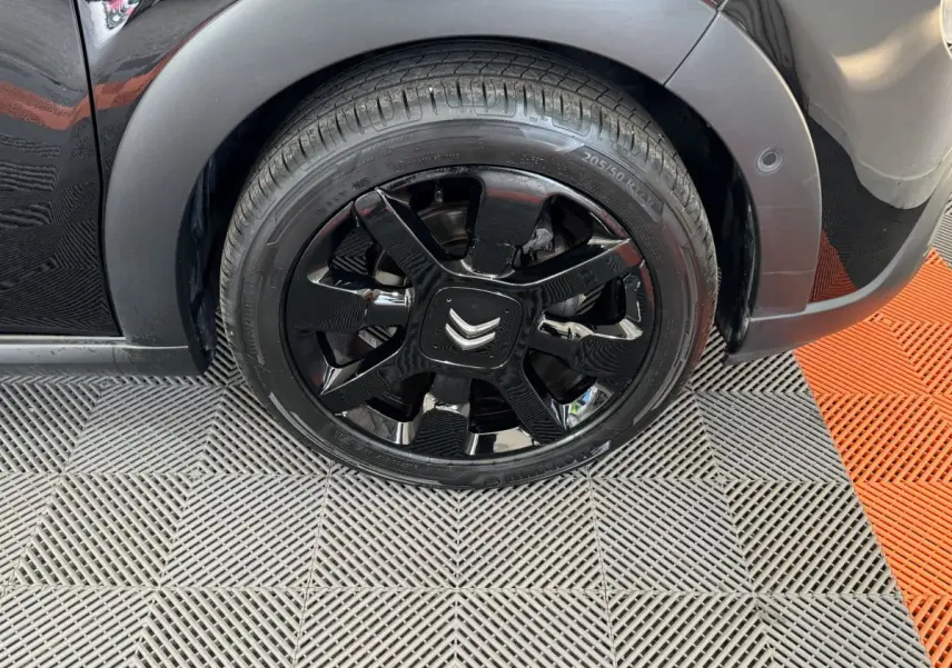 Gros plan sur la roue avant droite noire d'une Citroën C3 2019 avec jante noire brillante et logo Citroën central.