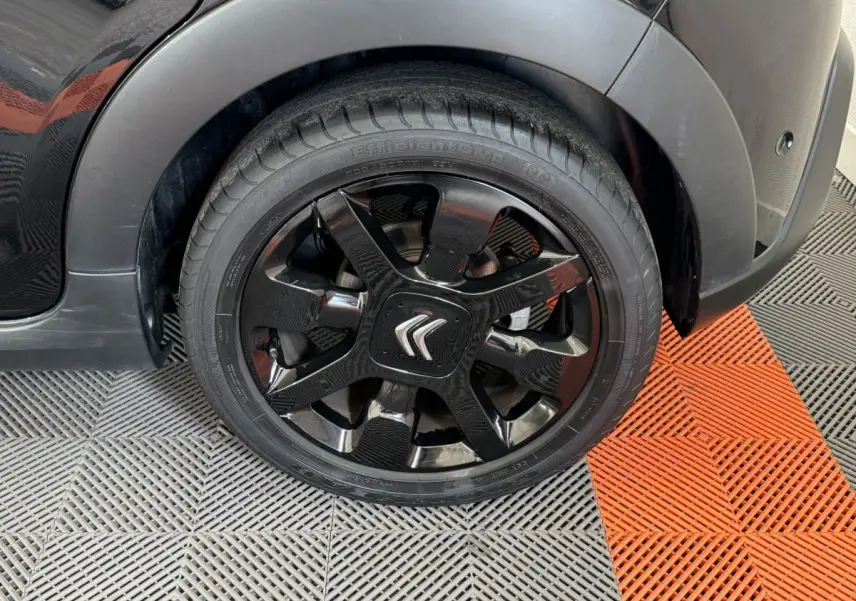 Gros plan sur la roue avant gauche noire d'une Citroën C3 2019 avec jante noire brillante et logo Citroën central.