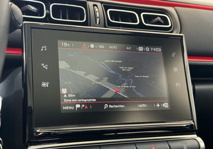 Écran tactile central de navigation dans l’habitacle noir et rouge d’une Citroën C3 2019 vue de face.