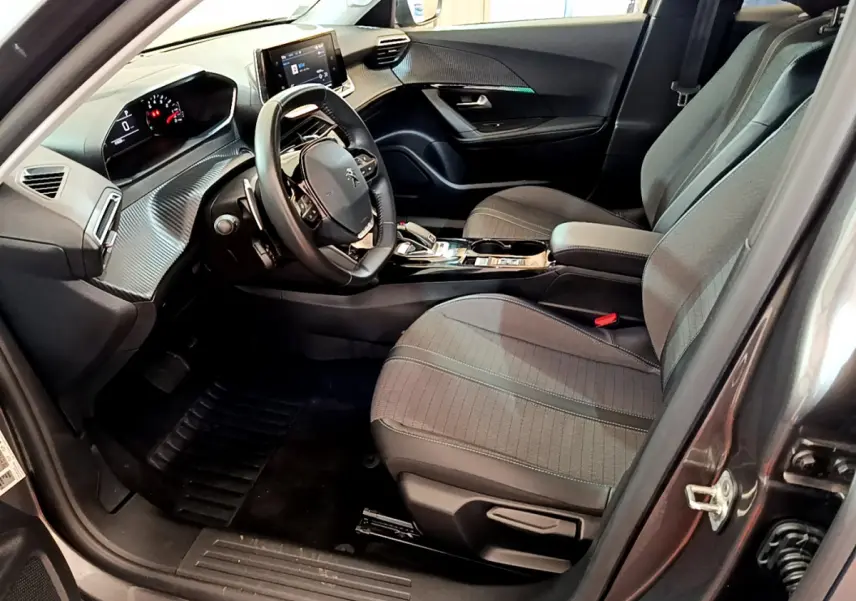 Intérieur gris foncé du Peugeot 2008 PureTech 130, vue côté conducteur avec tableau de bord et écran tactile visibles.