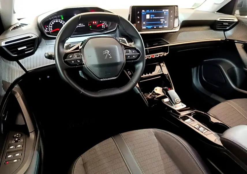 Vue intérieure avant du Peugeot 2008 2022 avec tableau de bord moderne et volant cuir multifonctions.