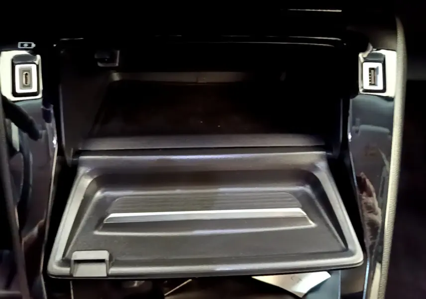 Gros plan sur la boîte à gants ouverte avec ports USB avant et arrière dans le Peugeot 2008 gris foncé 2022.