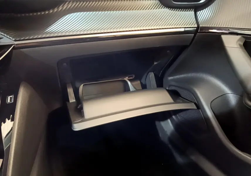 Vue intérieure du coffre à gants ouvert sur le côté passager d’un Peugeot 2008 gris foncé, avec tableau de bord texturé.