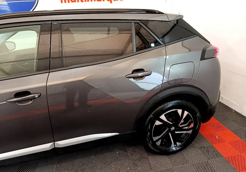 Vue côté droit arrière du Peugeot 2008 gris foncé 2022 avec jante alliage et lignes de caisse marquées.