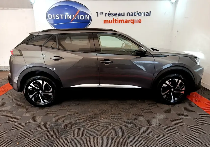 Peugeot 2008 gris foncé vue de profil côté droit, avec jantes noires et toit noir contrastant.