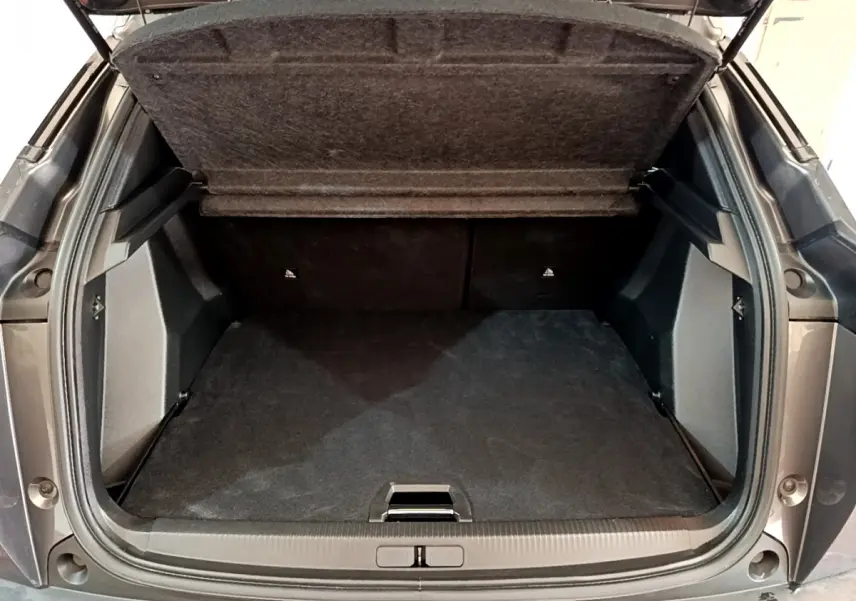 Coffre ouvert vu de l'arrière d'un Peugeot 2008 gris foncé, montrant un espace de chargement propre et spacieux.