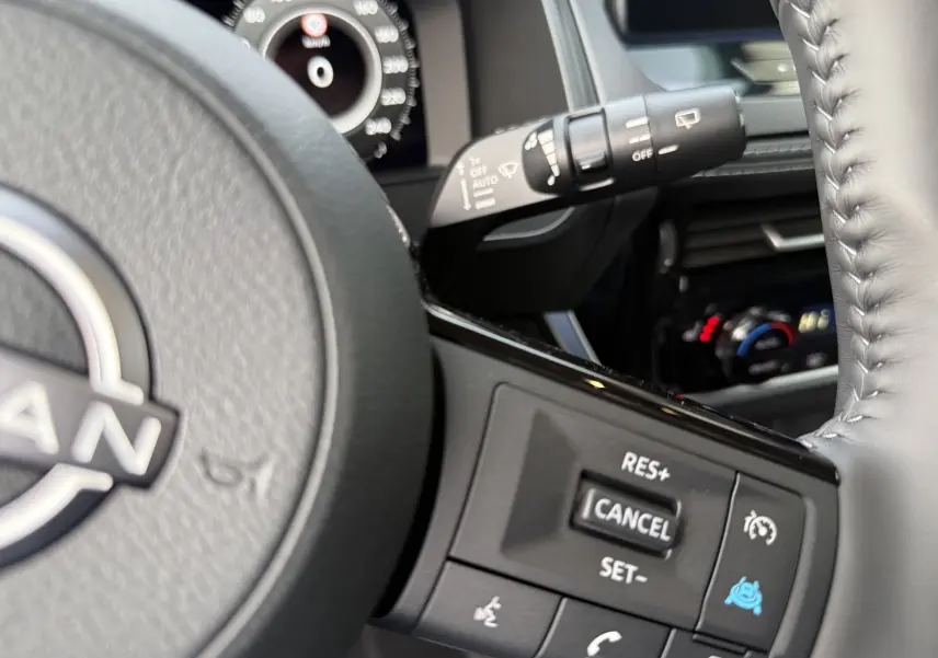 Gros plan sur le volant noir du Nissan Qashqai 2025, montrant les commandes de régulateur de vitesse côté droit.