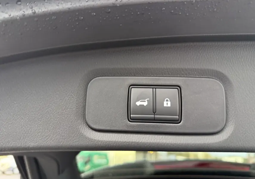 Boutons de commande de fermeture et verrouillage du coffre sur le hayon intérieur d’un Nissan Qashqai gris Squale Metal.