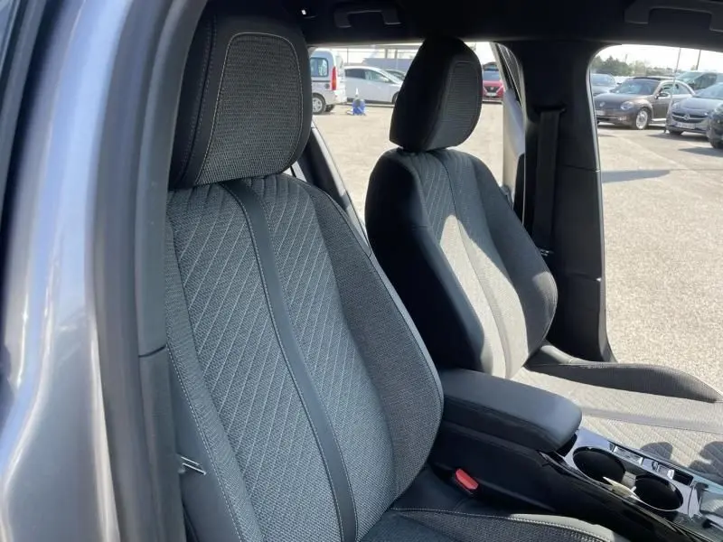 Vue intérieure des sièges avant gris tissu du Peugeot 2008 1.2 Hybrid 145 cv Allure e-DCS6, côté conducteur ouvert.