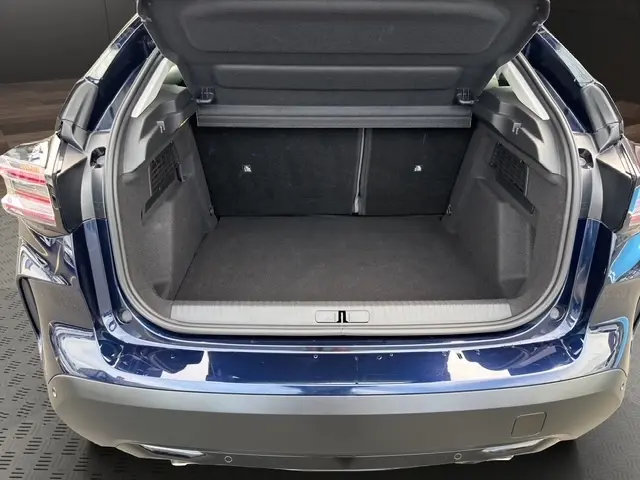 Coffre ouvert vu de l'arrière d'une Citroën C4 hybride 2025 bleu avec jantes alliage et feux arrière LED.