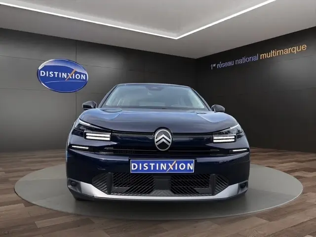 Vue avant d'une Citroën C4 hybride bleu foncé avec jantes alliage, éclairage LED et logo distinctif au centre.
