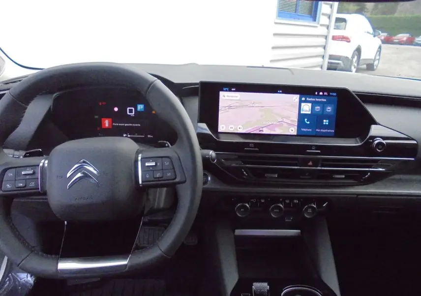Vue intérieure du tableau de bord et volant du Citroën C5 X 2022, avec écran tactile et commandes au volant visibles.