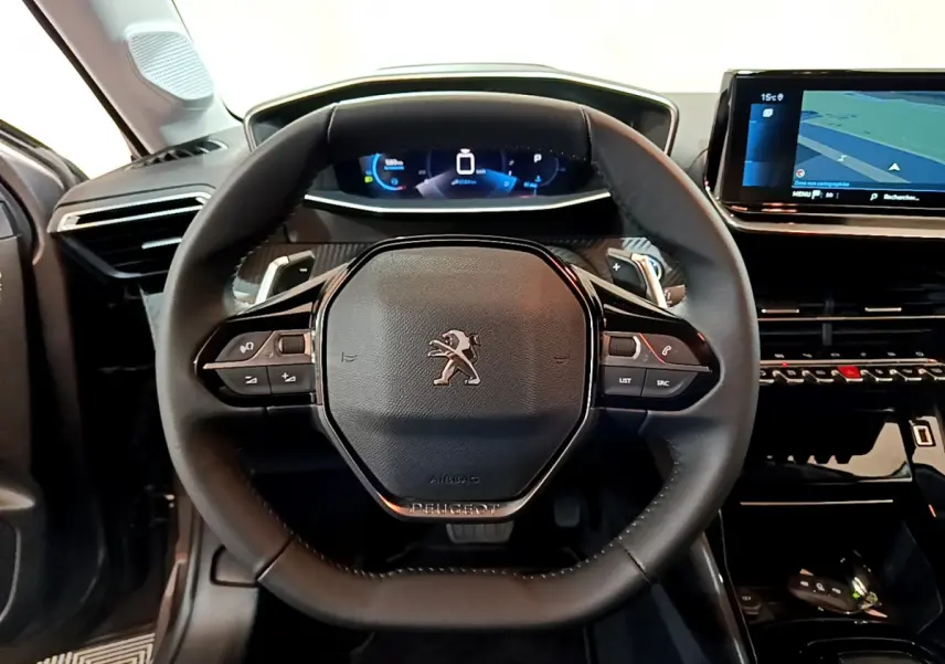 Vue frontale du volant cuir noir et du tableau de bord numérique de la Peugeot 208 gris foncé 2022 Allure Pack.