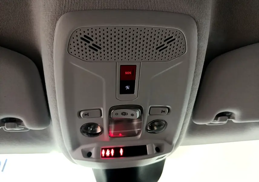 Vue intérieure du plafonnier gris clair avec bouton SOS et éclairage dans une Peugeot 208 gris foncé de 2022.