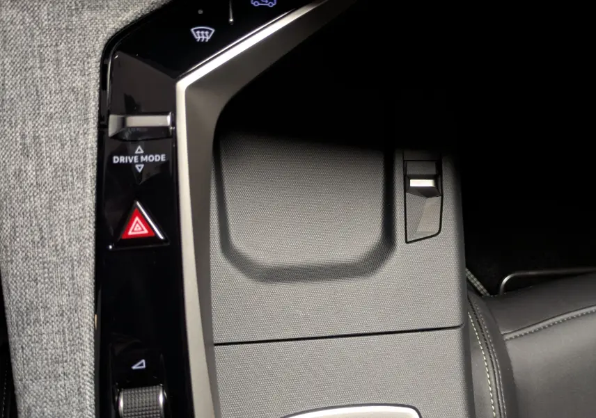 Gros plan sur la console centrale du Peugeot 3008 Hybrid 145 GT 2025, avec commandes tactiles et finition tissu gris.