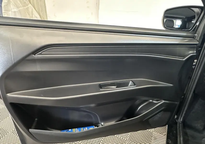 Intérieur montrant la porte côté conducteur noire avec poignée intégrée et rétroviseur extérieur caméra sur une Aixam Minauto E Access blanche 2025