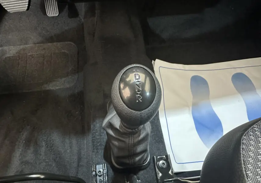 Le levier de vitesses automatique marqué D, N, R dans l'habitacle d'une Aixam MINAUTO E ACCESS blanc, vue rapprochée.