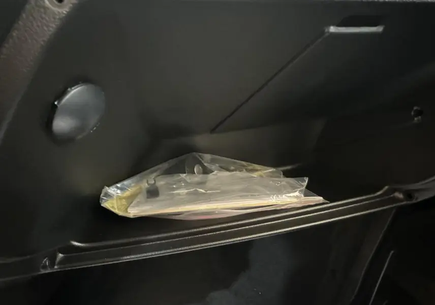 Gros plan sur la boîte à gants noire de l'AIXAM MINAUTO E ACCESS 2025 avec documents emballés à l'intérieur.