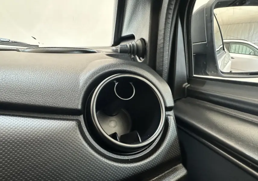 Gros plan sur la sortie d'air ronde côté conducteur de l'AIXAM MINAUTO E ACCESS blanc, avec rétroviseur extérieur équipé d'une caméra.