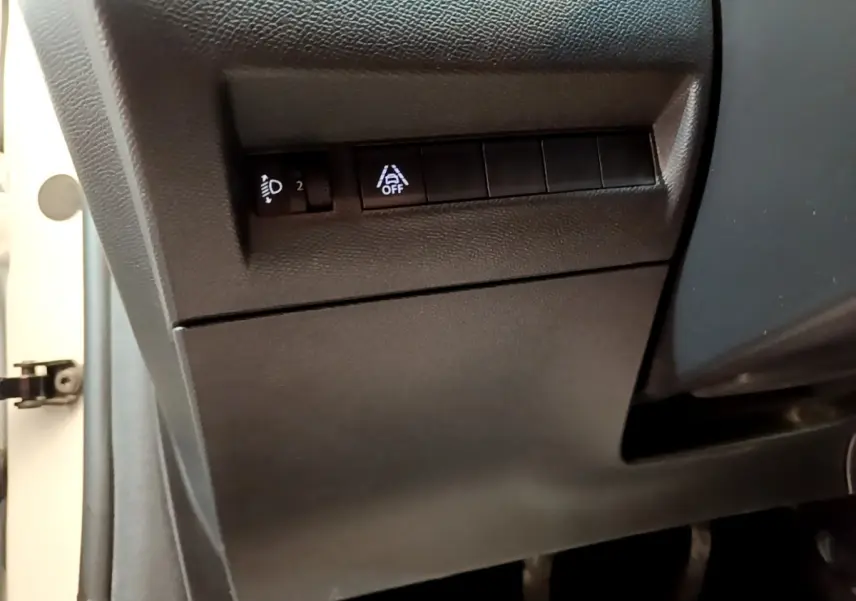Détail des commandes de réglage des phares et d'activation de l'assistance au maintien de voie dans une Peugeot 208 blanche, vue côté conducteur.