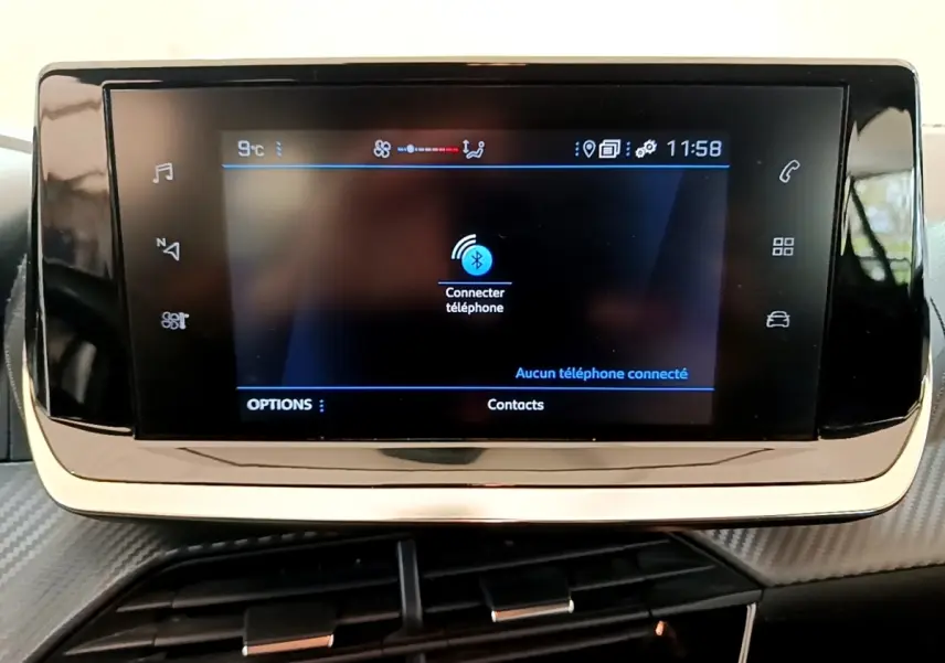 Écran tactile central de la Peugeot 208 blanc, affichant la connexion Bluetooth au téléphone, intérieur moderne.
