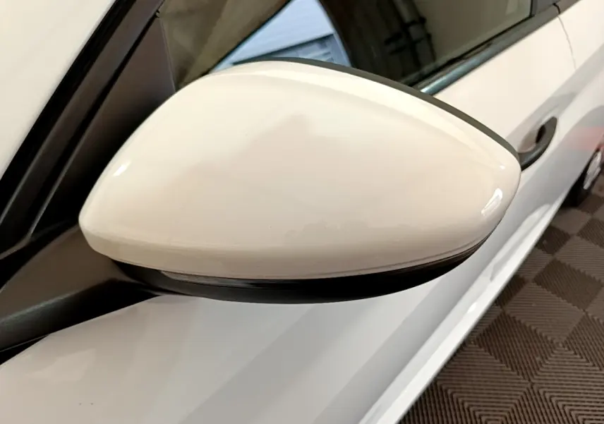 Rétroviseur côté conducteur blanc de la Peugeot 208 1.2 PT 75 S&S Premium vue rapprochée en intérieur.