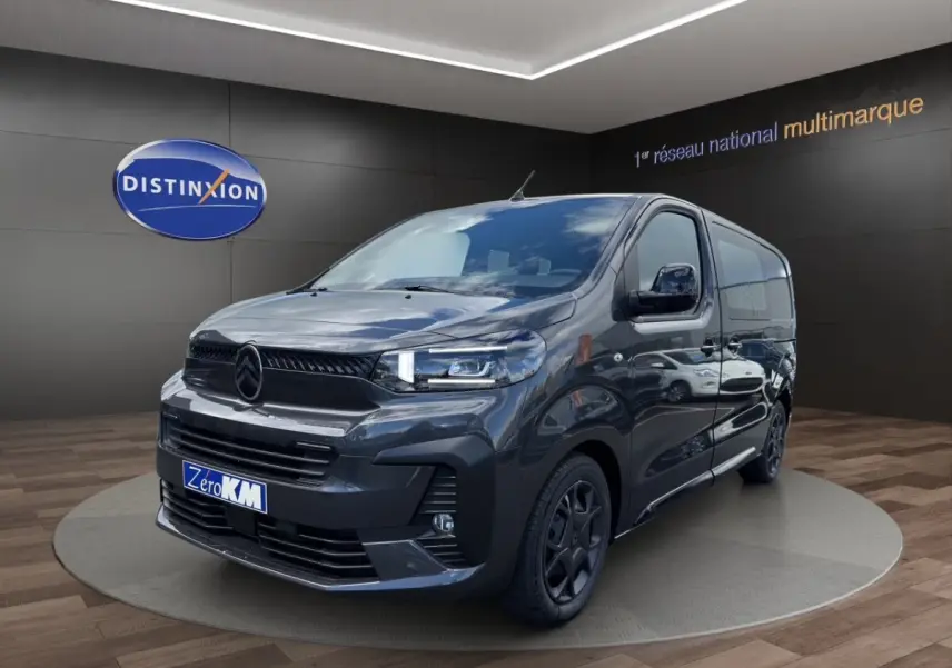 Vue 3/4 avant droit d’un Citroën Jumpy gris foncé avec calandre noire et jantes sombres, en showroom.