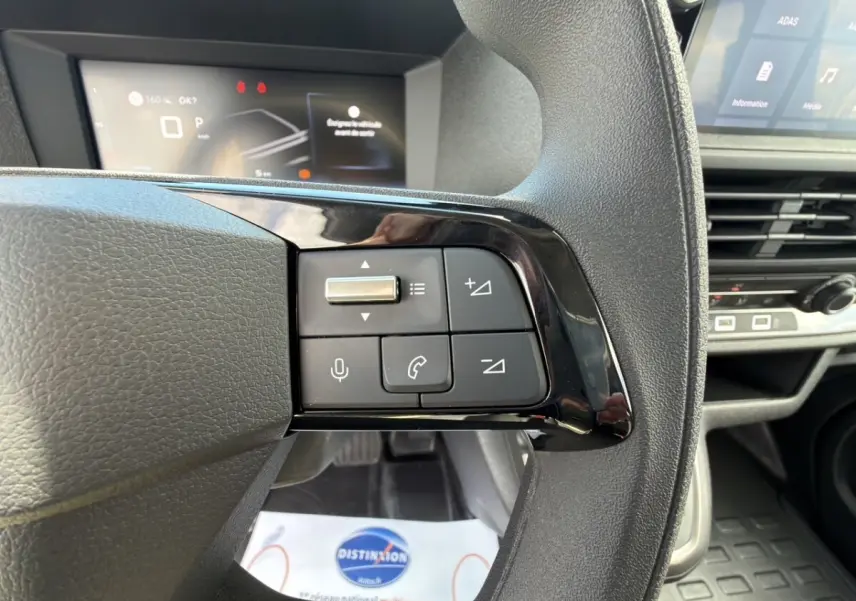 Gros plan sur le volant multifonctions noir du Citroën Jumpy gris foncé, avec commandes audio et téléphone visibles.