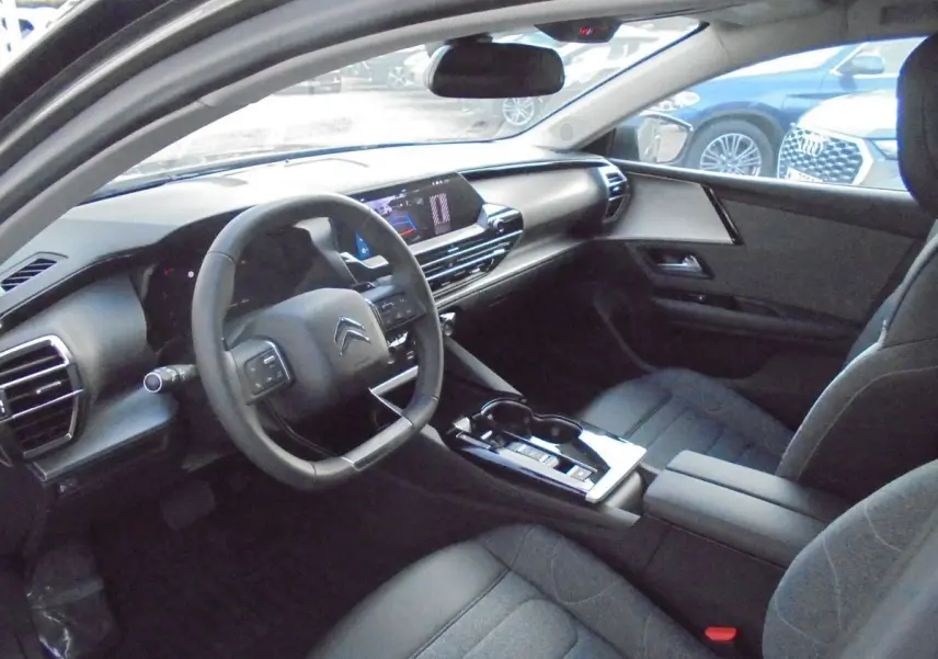 Intérieur du Citroën C5 X 2022 en gris platinium, vue côté conducteur montrant tableau de bord moderne et volant multifonction.