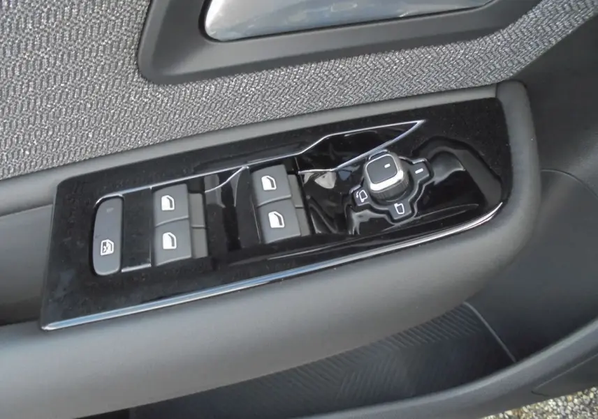 Gros plan sur les commandes de lève-vitres et rétroviseurs côté gauche d'une Citroën C5 X gris platinium 2022.