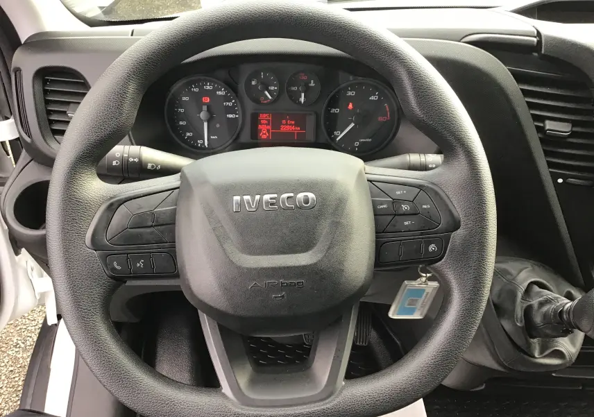 Vue rapprochée du volant noir du fourgon Iveco Daily 35S16 2022 avec tableau de bord et levier de vitesse manuel visibles.