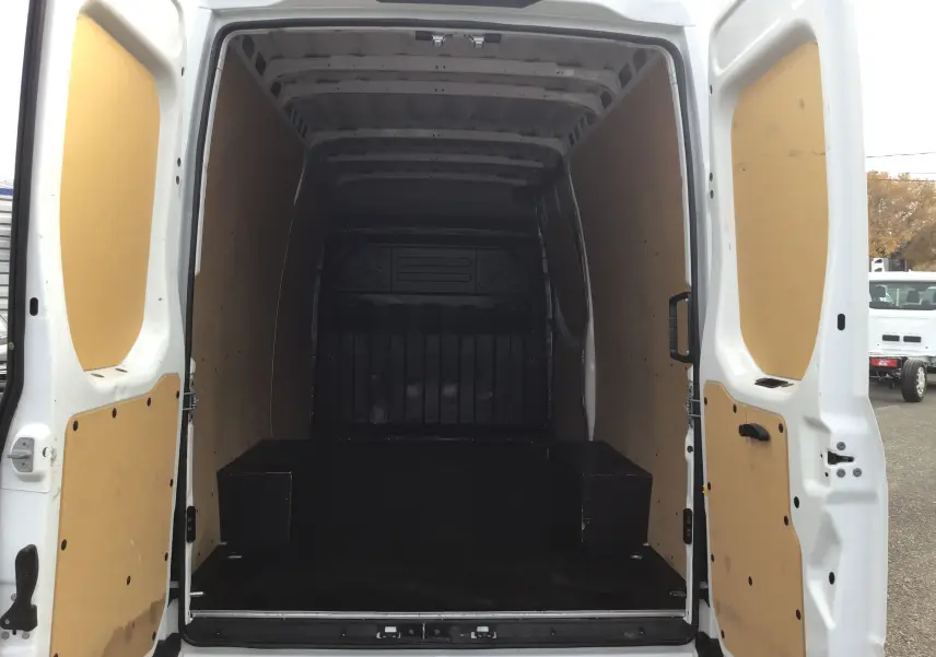 Vue arrière intérieure du fourgon Iveco Daily blanc 2022, montrant l'espace de chargement avec parois en bois clair.