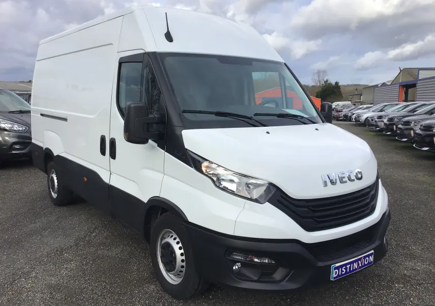 Vue 3/4 avant d'un fourgon Iveco Daily blanc avec calandre noire et rétroviseurs noirs sur parking.