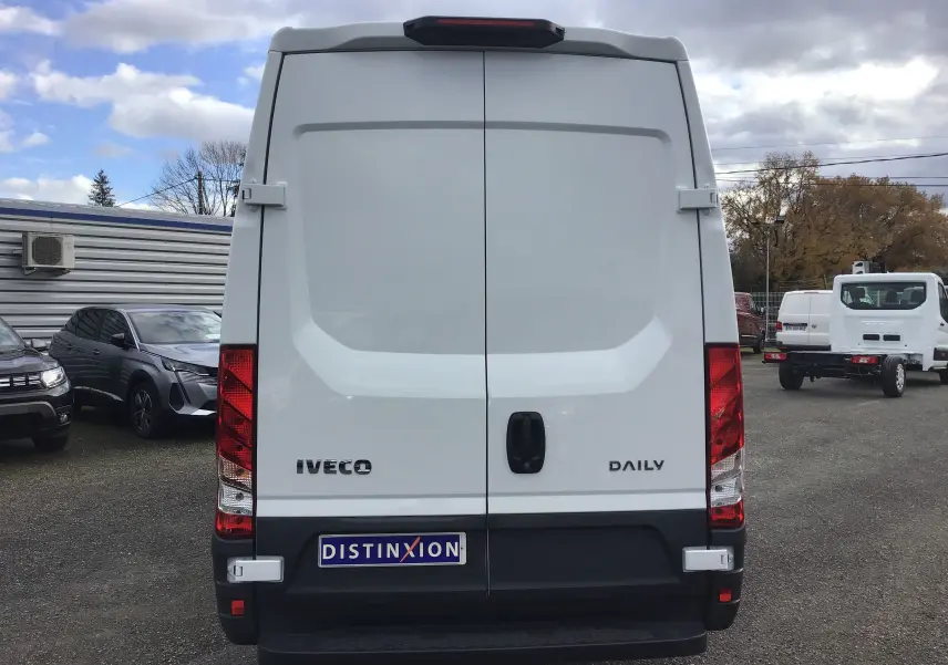 Vue arrière d'un fourgon Iveco Daily blanc 2022 avec portes battantes et feux rouges verticaux.