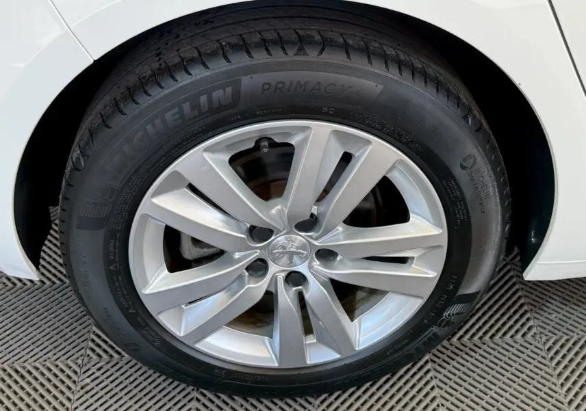 Gros plan sur la roue avant droite blanche d'une Peugeot 308 2021 avec jante alliage et pneu Michelin Primacy 4.
