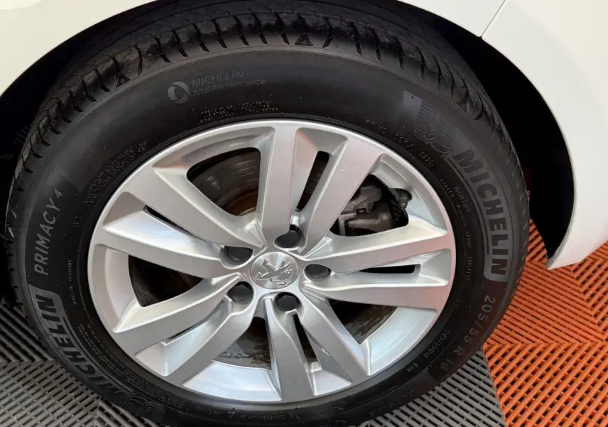 Gros plan sur la roue avant droite de la Peugeot 308 blanche, avec jante alliage et pneu Michelin Primacy 4 visible.