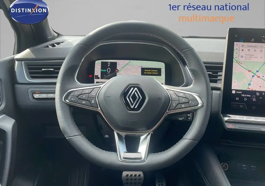 Vue frontale du volant en cuir perforé du Renault Captur E-Tech hybride 2025 avec tableau de bord numérique et écran tactile.