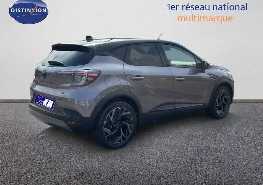 Vue 3/4 arrière droite d'un Renault Captur E-Tech hybride gris Cassiopée avec toit noir et jantes noires stylées.