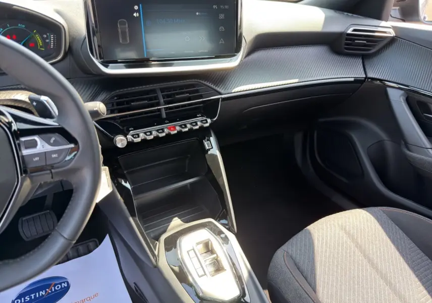Vue intérieure côté conducteur du Peugeot 2008 Hybrid 145 e-DCS6 STYLE 2025, tableau de bord noir avec écran tactile central.
