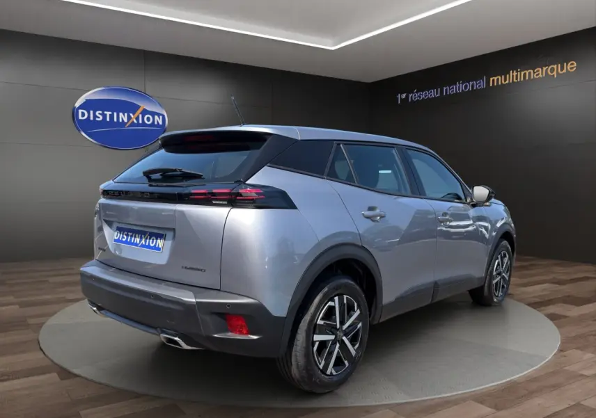 Peugeot 2008 Hybrid gris clair vue 3/4 arrière droit, feux LED et jantes alliage distinctives visibles.